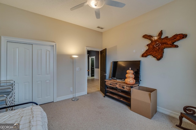 bedroom featuring ceiling fan, a closet, and light carpet