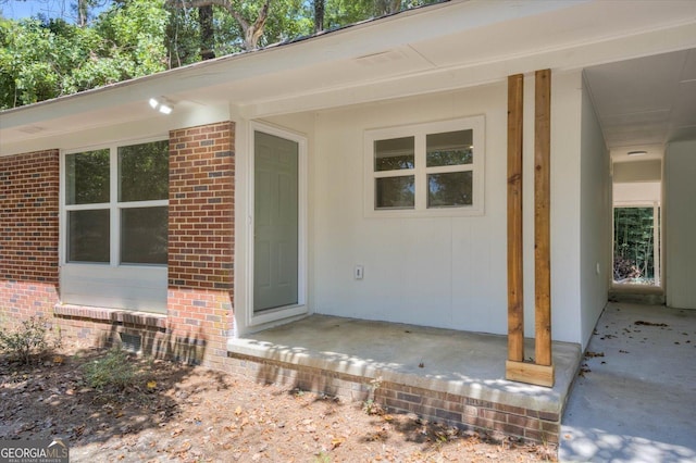 entrance to property featuring brick siding