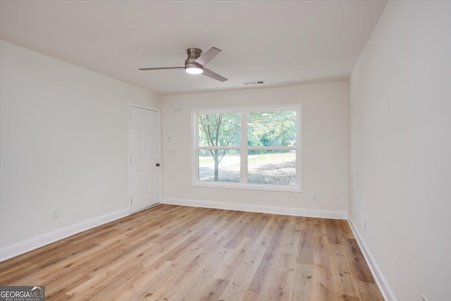 empty room with visible vents, ceiling fan, baseboards, and light wood-style floors