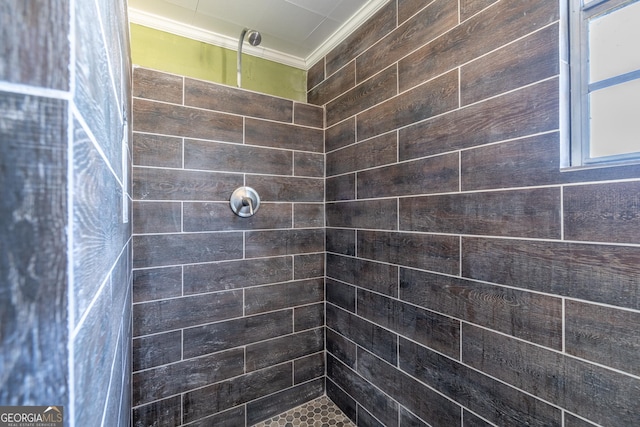 bathroom with tiled shower and ornamental molding