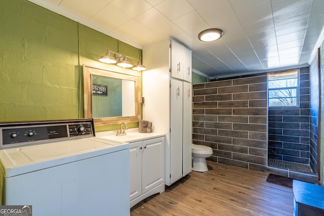 bathroom with hardwood / wood-style floors, vanity, ornamental molding, washer / dryer, and toilet