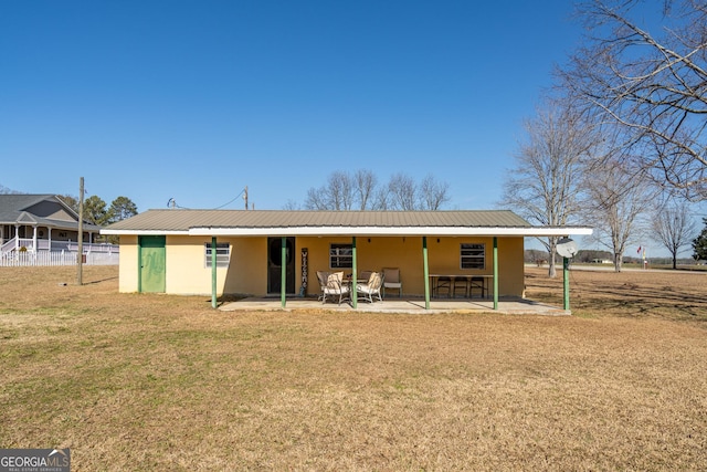 back of house with a patio area and a lawn