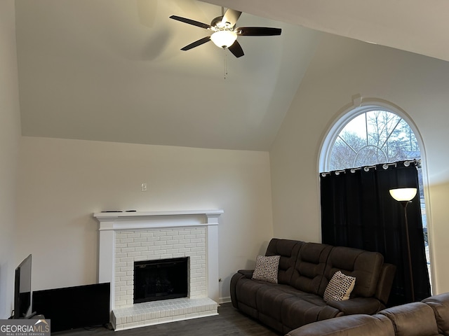 living room with ceiling fan, lofted ceiling, dark wood-type flooring, and a fireplace