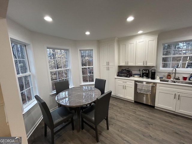 kitchen featuring dark hardwood / wood-style flooring, sink, stainless steel dishwasher, and white cabinets