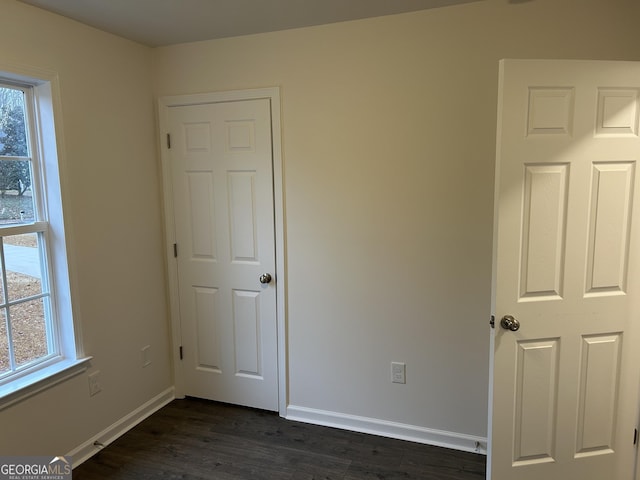 unfurnished bedroom featuring dark hardwood / wood-style flooring