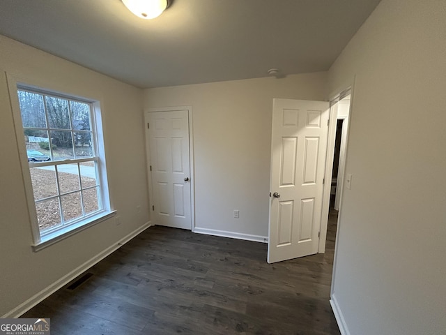 unfurnished bedroom with dark hardwood / wood-style flooring