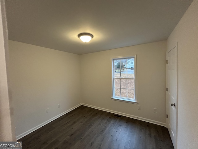 spare room with dark hardwood / wood-style flooring