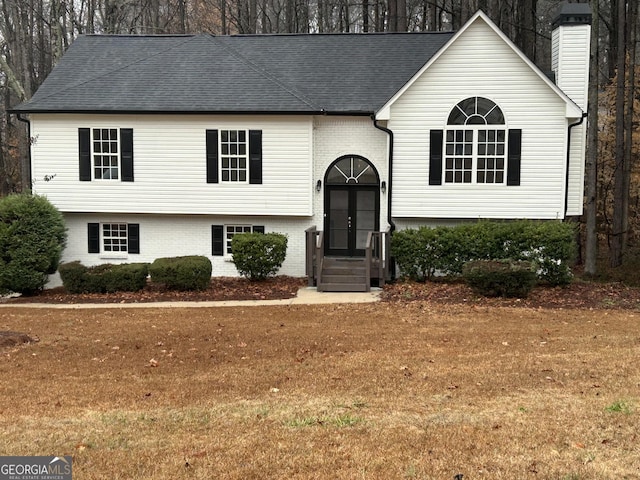 raised ranch featuring french doors and a front lawn