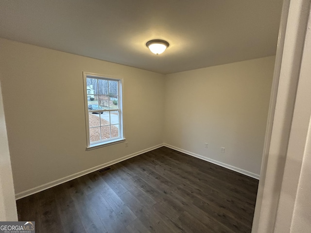 spare room featuring dark hardwood / wood-style flooring