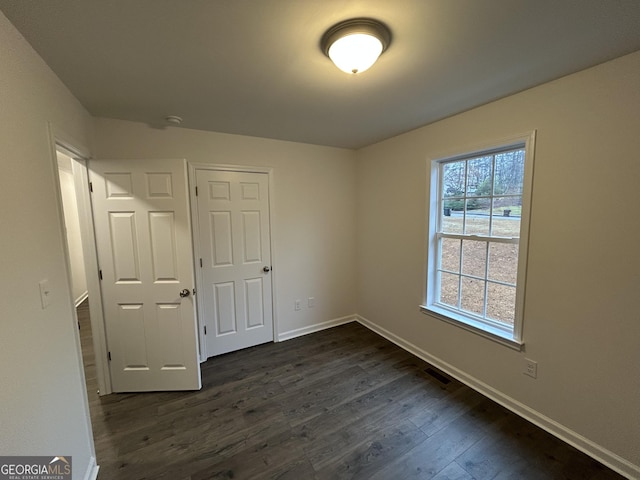 unfurnished bedroom with dark hardwood / wood-style flooring