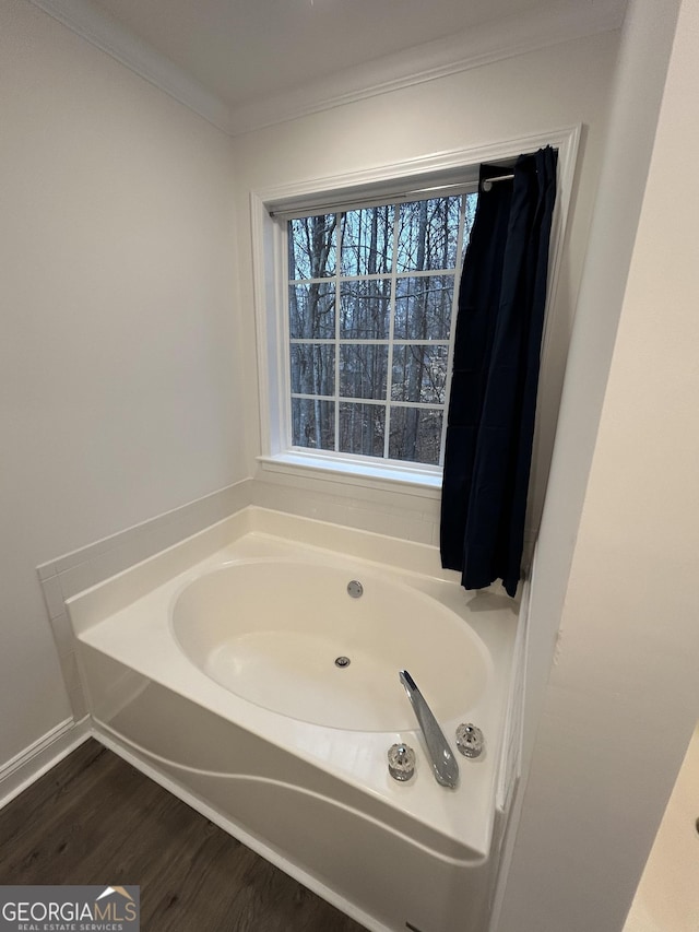 bathroom featuring crown molding, a bathing tub, and wood-type flooring