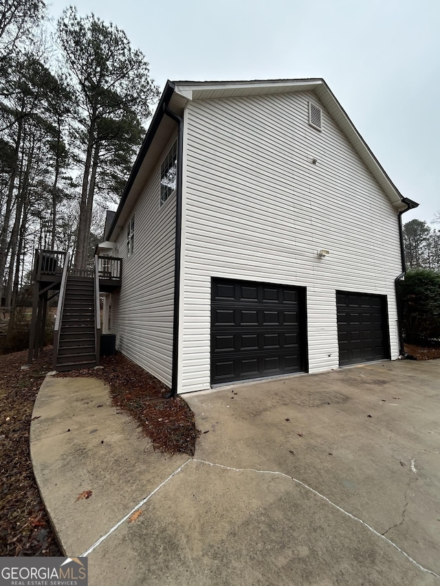 view of side of home featuring a garage and a deck