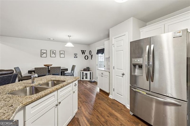 kitchen with pendant lighting, white cabinetry, sink, stainless steel fridge with ice dispenser, and light stone countertops