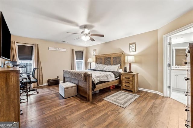 bedroom with ensuite bath and dark wood-type flooring