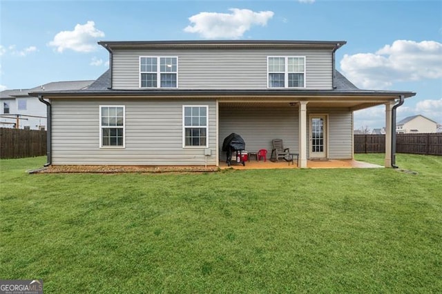 back of house featuring a lawn and a patio area