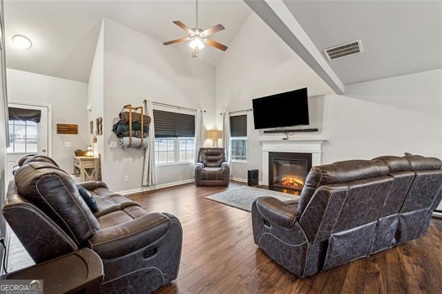 living room with ceiling fan, dark hardwood / wood-style floors, and high vaulted ceiling