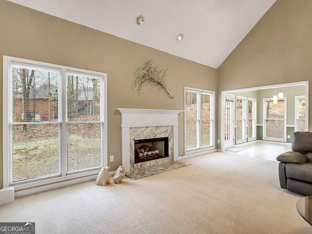 carpeted living room featuring a high end fireplace and high vaulted ceiling