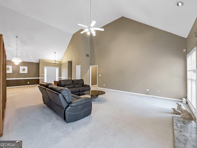 carpeted living room featuring ceiling fan with notable chandelier and high vaulted ceiling