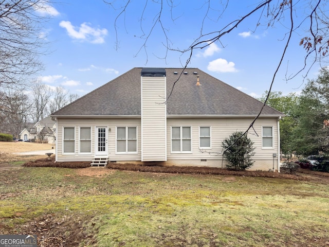 rear view of property featuring a lawn