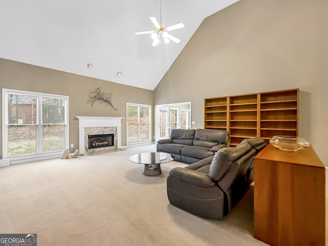 living room with ceiling fan, high vaulted ceiling, carpet flooring, and a high end fireplace