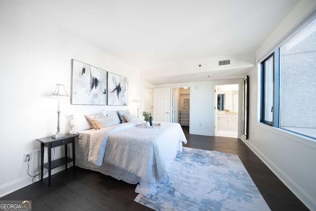 bedroom with dark wood-type flooring and ensuite bath