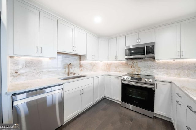 kitchen with sink, decorative backsplash, stainless steel appliances, and white cabinets