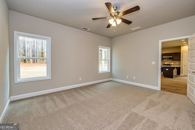 unfurnished bedroom with light carpet and ceiling fan