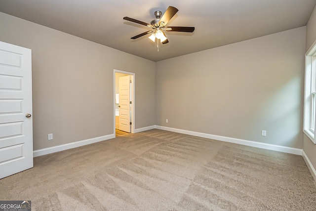 empty room featuring ceiling fan and light colored carpet