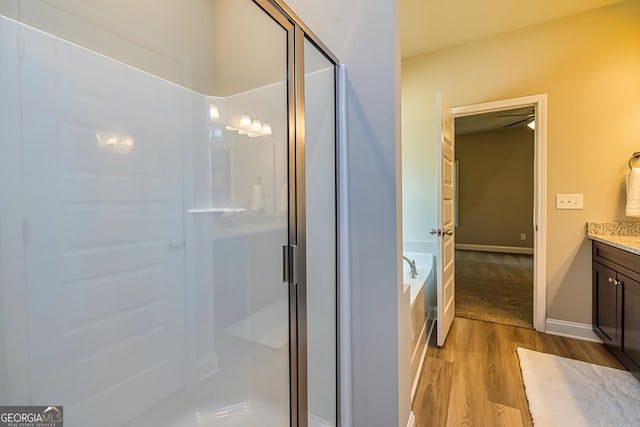 bathroom featuring vanity, hardwood / wood-style flooring, and shower with separate bathtub