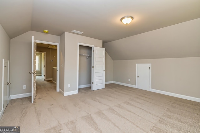 additional living space with vaulted ceiling and light colored carpet