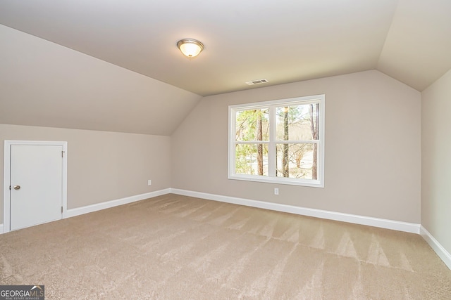 additional living space featuring lofted ceiling and carpet floors