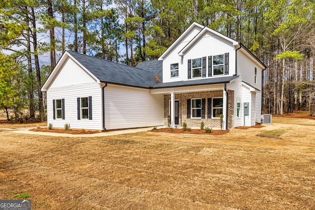 view of front of home featuring cooling unit and a front lawn