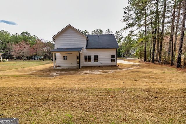 back of house with a lawn and a patio