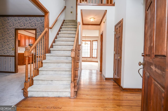 foyer entrance featuring ornamental molding and light hardwood / wood-style flooring