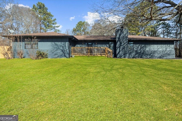 rear view of house with a yard and a deck