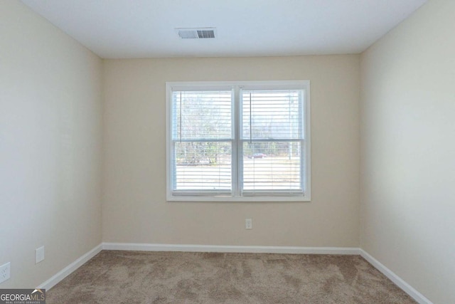 unfurnished room with light colored carpet and a wealth of natural light