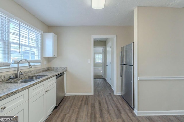 kitchen featuring white cabinetry, stainless steel appliances, sink, and hardwood / wood-style flooring