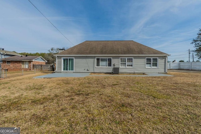 rear view of property featuring a patio, a yard, and central AC