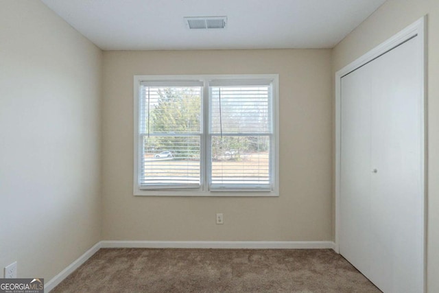 unfurnished bedroom with light carpet and a closet