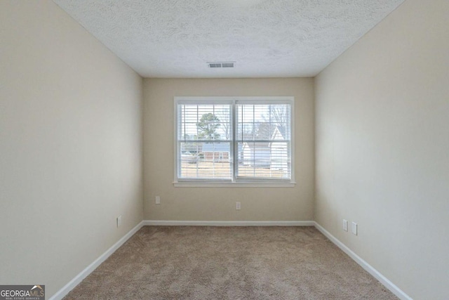 carpeted empty room with a textured ceiling