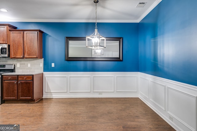 unfurnished dining area featuring hardwood / wood-style flooring, ornamental molding, and a chandelier