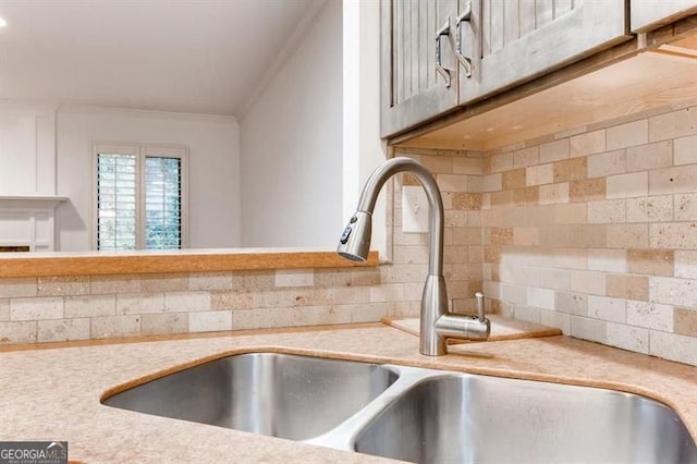 kitchen featuring tasteful backsplash, sink, and ornamental molding