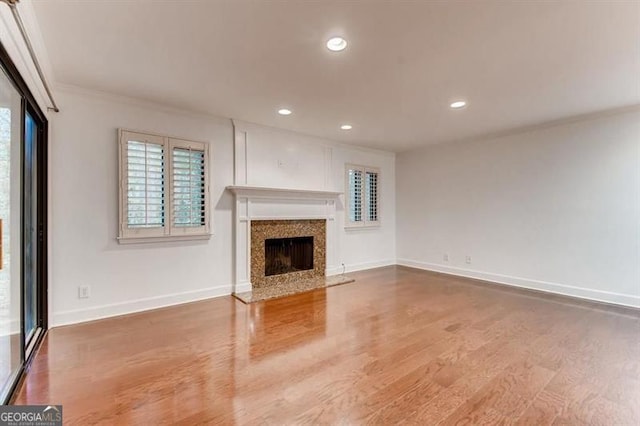 unfurnished living room featuring hardwood / wood-style flooring and a high end fireplace