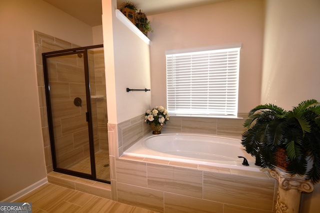 bathroom featuring a bath and a stall shower
