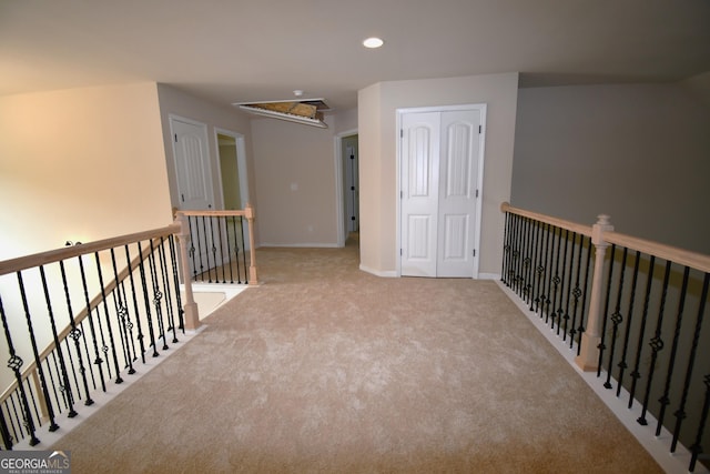 hallway with an upstairs landing, attic access, carpet, baseboards, and recessed lighting