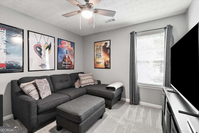 home theater with light carpet, ceiling fan, and a textured ceiling