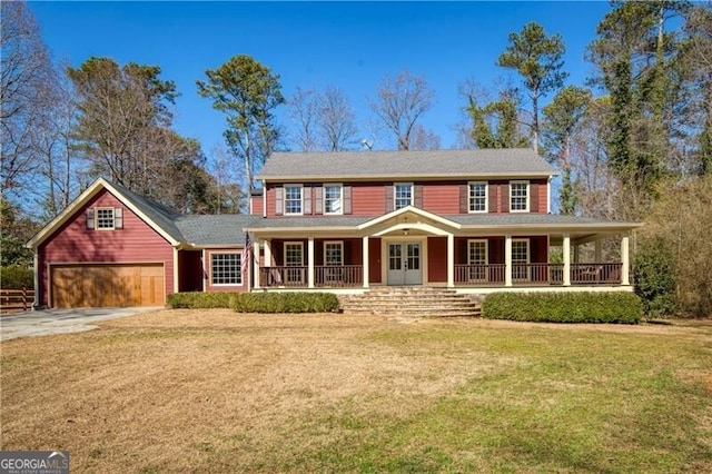 view of front of house featuring a garage, driveway, a front lawn, and a porch