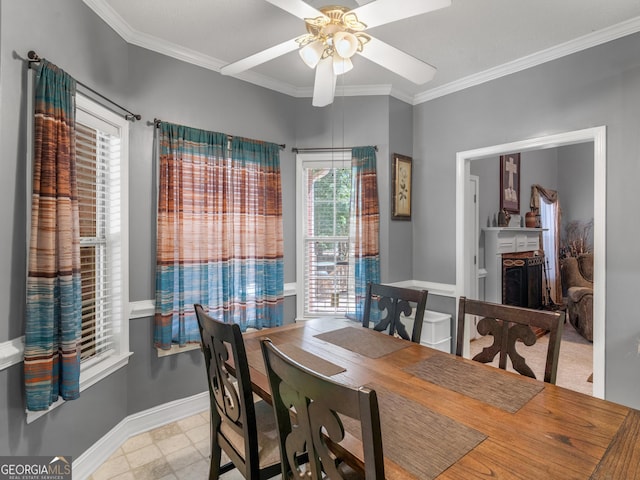 dining room featuring a ceiling fan, a brick fireplace, crown molding, and baseboards