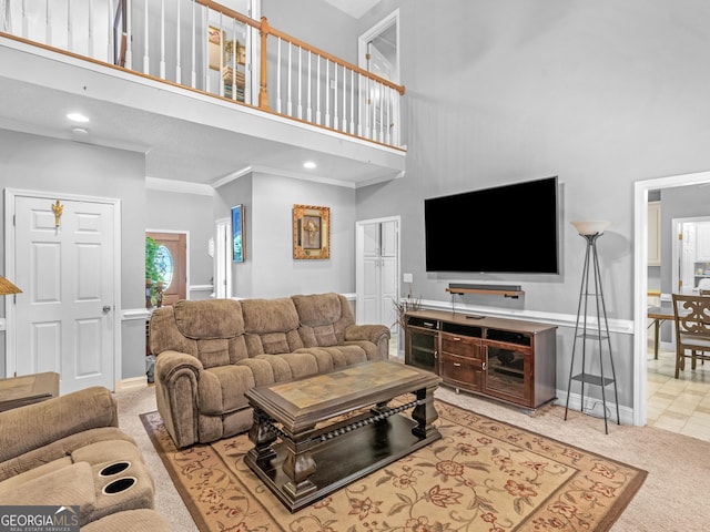 living room featuring crown molding, baseboards, a towering ceiling, and light colored carpet