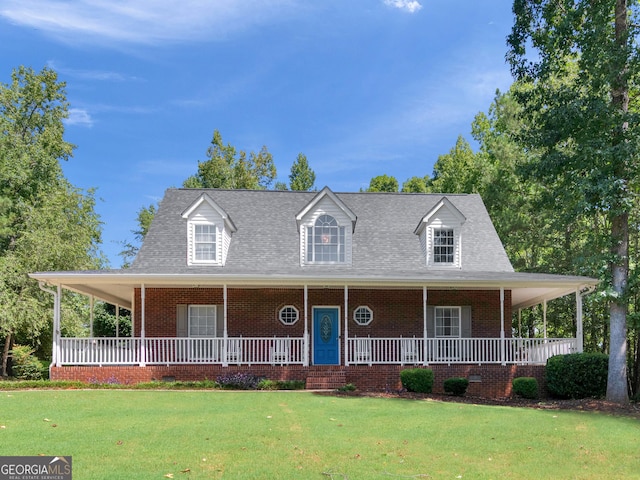 farmhouse inspired home with covered porch, brick siding, and a front yard